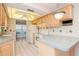 Efficient kitchen with light wood cabinets, ample counter space, and a breakfast bar at 4961 Grist Mill Cir, New Port Richey, FL 34655