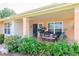 Inviting front porch with seating area, well-manicured landscaping, and light peach exterior at 4961 Grist Mill Cir, New Port Richey, FL 34655
