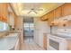 Well-lit kitchen with light wood cabinets, updated appliances, and a view of the dining area at 4961 Grist Mill Cir, New Port Richey, FL 34655
