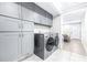 Bright laundry room with gray cabinets and access to living area at 2102 E Annie St, Tampa, FL 33612