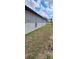 Side view of the property's exterior shows a low-maintenance yard with a partially cloudy sky overhead at 3001 E 25Th Ave, Tampa, FL 33605