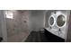 Bathroom with marble-look tile shower, dual vanity with modern lighting at 3001 E 25Th Ave, Tampa, FL 33605