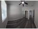 A well-lit bedroom featuring gray wood floors, a ceiling fan, and a mirrored closet at 3001 E 25Th Ave, Tampa, FL 33605