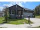Charming home featuring dark gray exterior with stone accents, a gray garage door, and well-manicured lawn at 3001 E 25Th Ave, Tampa, FL 33605