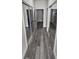 Hallway with wood-look floors, mirrored closet doors, and a bathroom at 3001 E 25Th Ave, Tampa, FL 33605