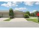 Townhouse with driveway and two-car garage, landscaped front yard, and blue sky at 6357 Shore Vista Pl, Apollo Beach, FL 33572