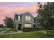 Charming two-story home with manicured lawn, landscaped bushes and colorful sky at sunset at 6357 Shore Vista Pl, Apollo Beach, FL 33572