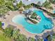 Aerial view of a luxurious community pool with water slides, a splash pad, and tropical landscaping at 6357 Shore Vista Pl, Apollo Beach, FL 33572
