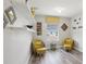 Cozy sitting room with yellow armchairs and ottoman with wood-look floors at 6357 Shore Vista Pl, Apollo Beach, FL 33572