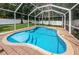 Fully enclosed kidney-shaped pool with brick deck at 903 Woodbridge Ct, Safety Harbor, FL 34695