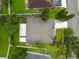 Aerial view of a house with a gray roof, green lawn and mature trees on a suburban street at 1130 Big Creek Dr, Wesley Chapel, FL 33544