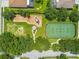 Aerial view showcasing a community playground and tennis court surrounded by mature trees at 1130 Big Creek Dr, Wesley Chapel, FL 33544