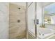 Bathroom featuring a glass enclosed shower and soaking tub with view of the outside at 1130 Big Creek Dr, Wesley Chapel, FL 33544