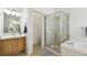 Bathroom showcasing wood vanity with sink, a glass shower enclosure, and neutral tile floor at 1130 Big Creek Dr, Wesley Chapel, FL 33544