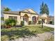 Inviting single-story home with a well-manicured lawn, elegant arched windows, and a convenient attached garage at 1130 Big Creek Dr, Wesley Chapel, FL 33544