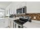 Modern kitchen with stainless steel appliances, white cabinets, and tiled backsplash at 1130 Big Creek Dr, Wesley Chapel, FL 33544