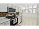 Bright kitchen with stainless steel appliances, white cabinets, and tile flooring at 1130 Big Creek Dr, Wesley Chapel, FL 33544