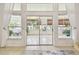 Sunroom featuring sliding glass doors and white curtains that lead to the spacious screened lanai at 1130 Big Creek Dr, Wesley Chapel, FL 33544