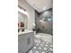 Modern bathroom with gray cabinets, hexagonal tile floor, and a bathtub at 3410 E Henry Ave, Tampa, FL 33610