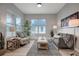 Bright living room featuring a comfy sofa, armchair, and large windows at 3410 E Henry Ave, Tampa, FL 33610