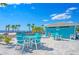 Beachfront patio area with a blue table and chairs, offering a relaxing ocean view at 5457 Leeward Ln, New Port Richey, FL 34652