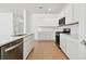 Modern kitchen with white cabinets, stainless steel appliances and light wood flooring at 3008 Forest Meadow Ave, Valrico, FL 33594