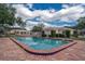 Inviting community pool with brick patio and adjacent building at 11728 Raintree Dr, Temple Terrace, FL 33617