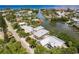 Scenic aerial shot showcases waterfront property with private dock amidst lush tropical surroundings at 210 Lakeview Dr, Anna Maria, FL 34216