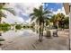 Secluded backyard oasis with lounge seating, water views, and lush palm trees, ideal for outdoor enjoyment at 210 Lakeview Dr, Anna Maria, FL 34216