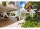 Waterfront backyard featuring a covered patio with seating, a dock, and lush tropical landscaping, perfect for relaxation at 210 Lakeview Dr, Anna Maria, FL 34216