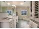 Large bathroom with double vanity, shuttered window, and step up soaking tub at 210 Lakeview Dr, Anna Maria, FL 34216
