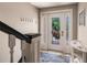 Bright entryway featuring tiled floors, coat hooks, and a front door showcasing the lush outdoor scenery at 210 Lakeview Dr, Anna Maria, FL 34216