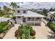 Charming two-story home with a light exterior, well-manicured landscaping, and a covered balcony at 210 Lakeview Dr, Anna Maria, FL 34216