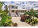 Beautifully landscaped home with a two-story layout, covered balconies, and a well-maintained yard with mature trees at 210 Lakeview Dr, Anna Maria, FL 34216