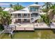 Beautiful two-story waterfront property with a private dock, outdoor seating, and manicured lawn at 210 Lakeview Dr, Anna Maria, FL 34216