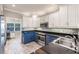 Well-lit kitchen with stainless steel appliances, granite countertops, and blue and white cabinetry at 210 Lakeview Dr, Anna Maria, FL 34216