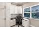 Office area featuring a built-in desk, white cabinets, and a large window at 210 Lakeview Dr, Anna Maria, FL 34216
