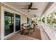 This covered patio offers water views and features wicker seating, ceiling fans, and sliding door access to the indoors at 210 Lakeview Dr, Anna Maria, FL 34216