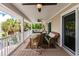 Relax on this covered patio featuring wicker furniture, a swing, ceiling fans, and views of lush greenery and waterway at 210 Lakeview Dr, Anna Maria, FL 34216