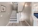 Staircase with wood look floors, white trim and walls with access to kitchen at 210 Lakeview Dr, Anna Maria, FL 34216
