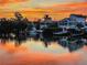Beautiful waterfront homes reflecting a vibrant sunset onto the water, showcasing a serene and picturesque neighborhood at 210 Lakeview Dr, Anna Maria, FL 34216