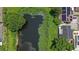 Aerial view showcasing a home with a pond and solar panels at 8816 Ascot Ct, Tampa, FL 33634