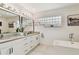 Elegant bathroom featuring a soaking tub and double vanity at 5709 E Longboat Blvd, Tampa, FL 33615