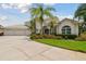 Two-story house with three-car garage and lush landscaping at 5709 E Longboat Blvd, Tampa, FL 33615