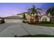 Two-story house with three-car garage and landscaping at 5709 E Longboat Blvd, Tampa, FL 33615