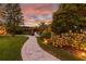 Landscaped backyard with stone pathway, leading to a pergola and fire pit at 5709 E Longboat Blvd, Tampa, FL 33615