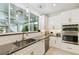 White kitchen with stainless steel appliances and marble countertops at 5709 E Longboat Blvd, Tampa, FL 33615