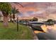 Sunset view of a boat slip with a docked boat and palm trees at 5709 E Longboat Blvd, Tampa, FL 33615