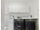 Laundry room with stacked washer and dryer and cabinets at 5709 E Longboat Blvd, Tampa, FL 33615