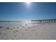 View of beach with pier and ocean under blue sky at 16308 Gulf Blvd # 209, Redington Beach, FL 33708
